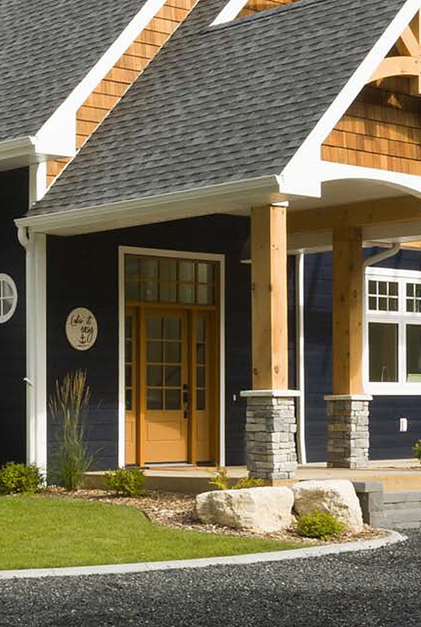 Craftsman front entry with wood-look door and timber porch