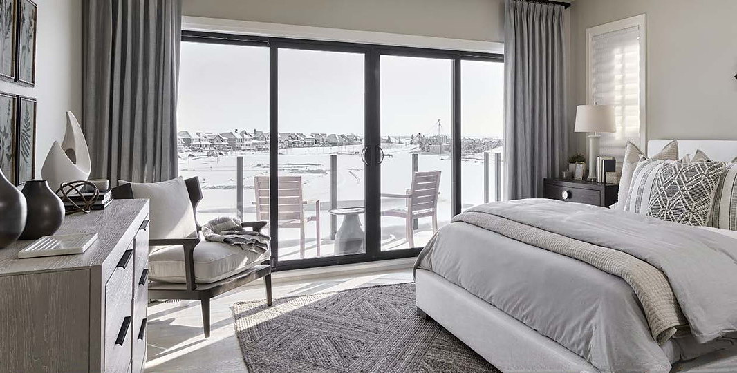 Bedroom with a Durabuilt sliding patio door opening onto a lakeside deck